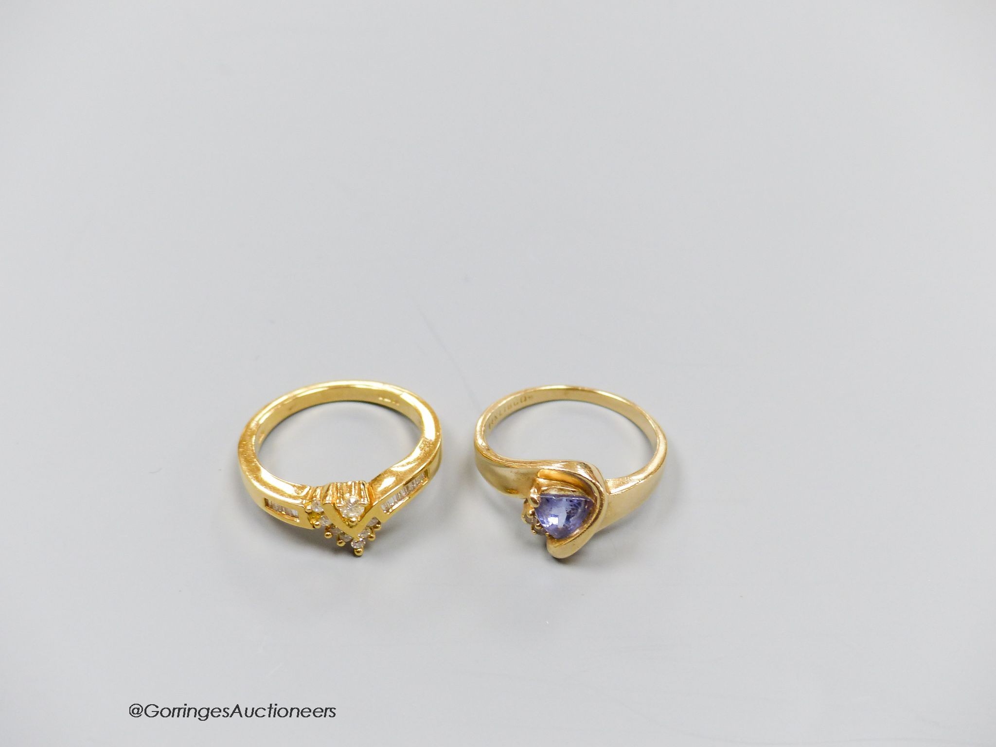 An 18ct gold and diamond dress ring, size N, gross 4.5g, and a 14k gold, diamond and tanzanite ring, size N, gross 3.7g.